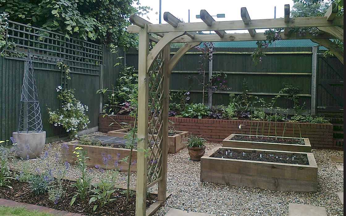 The far end of this small garden in Balham was zoned off into an attractive formal kitchen garden with raised beds using a border of flowering perennials and a pergola archway to give vertical interest.